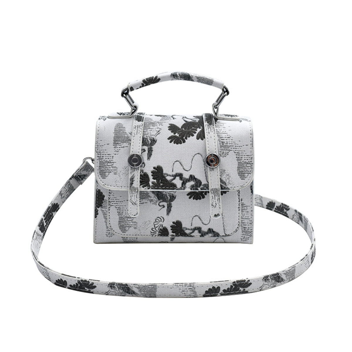A structured sling bag and handbag with a top handle and detachable shoulder strap, featuring a black and white botanical and abstract pattern over a light gray base, shown on a plain white background.